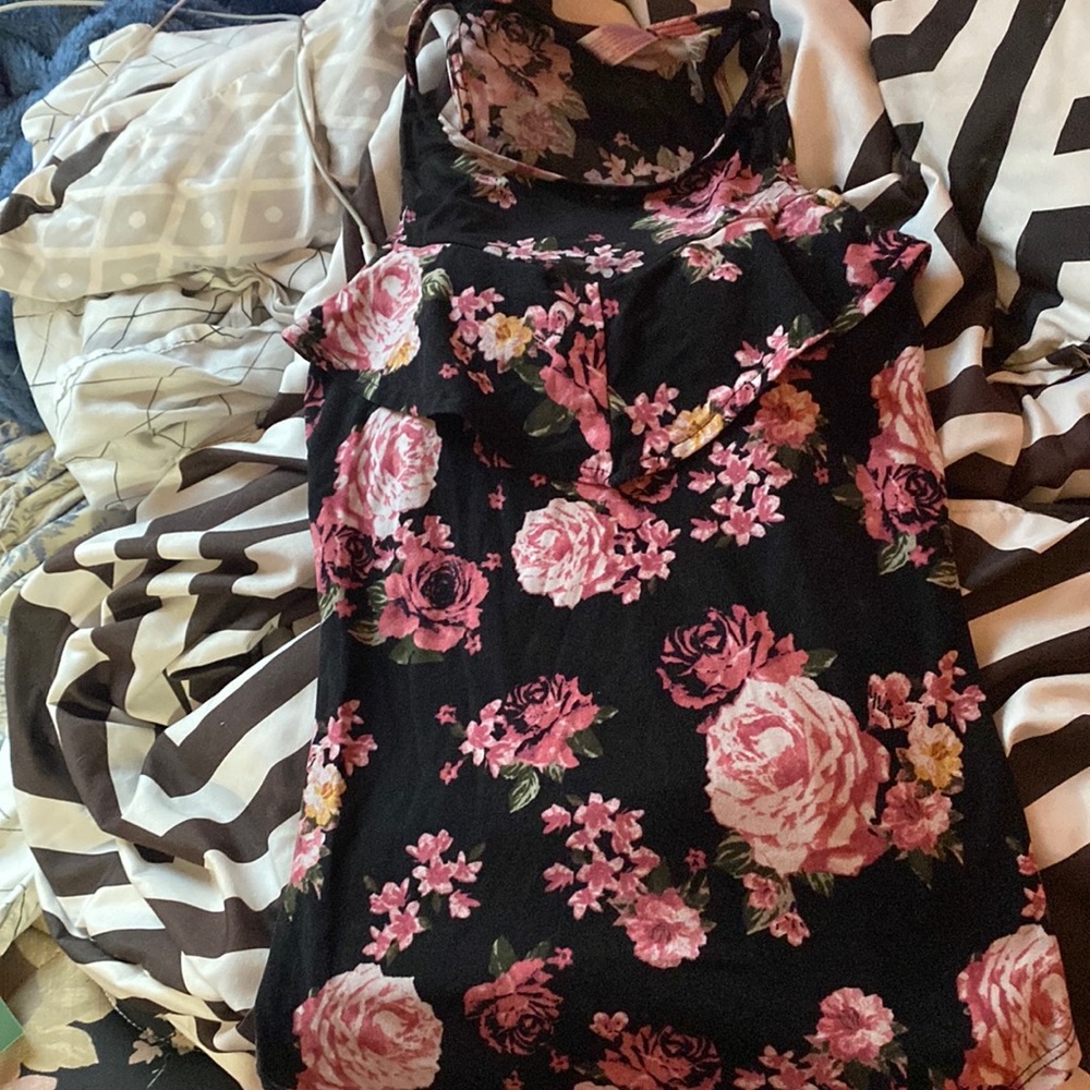 A sleeveless flower top with a ruffle on top at neckline